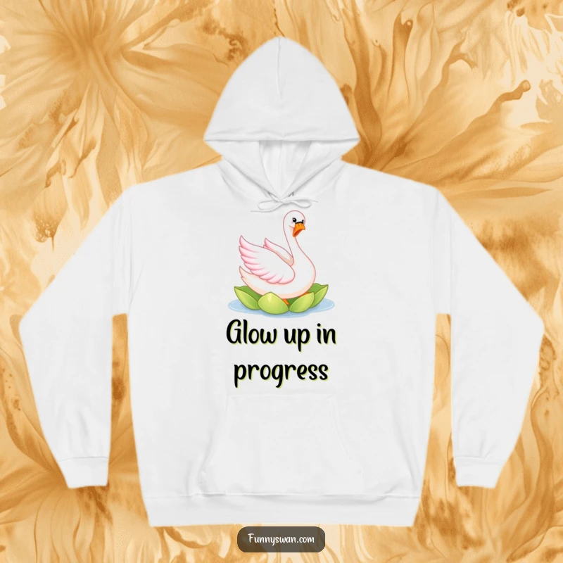 Funny pink swan hoodie featuring a joyful, elegantly twirling bird with bright pink feathers on a lily pad.
